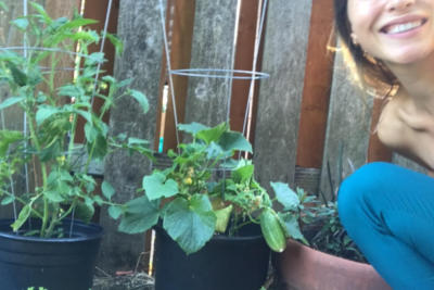 Two plants and a woman smiling